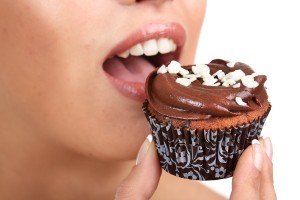 Closeup of woman eating chocolate cupcake